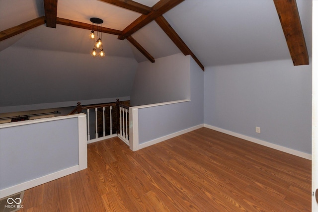 bonus room featuring lofted ceiling with beams, baseboards, and wood finished floors