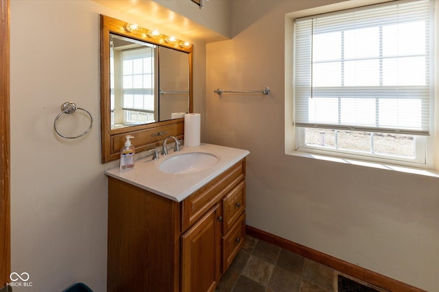 bathroom with a wealth of natural light, visible vents, vanity, and baseboards