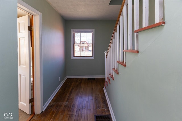 hall with baseboards, visible vents, hardwood / wood-style floors, stairs, and a textured ceiling