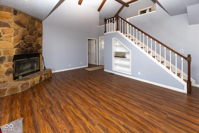 unfurnished living room with built in shelves, wood finished floors, a fireplace, and stairs