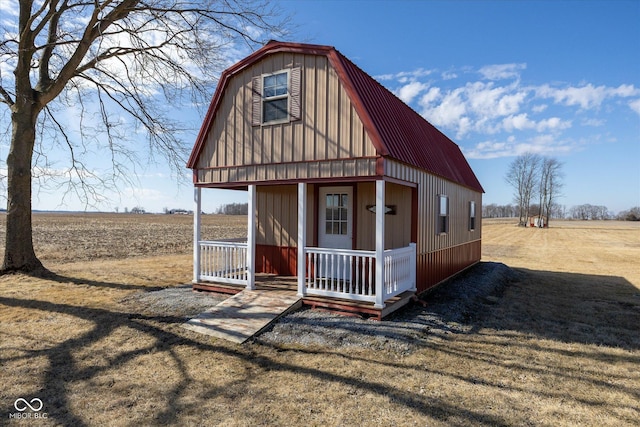 view of outbuilding featuring a porch and a rural view