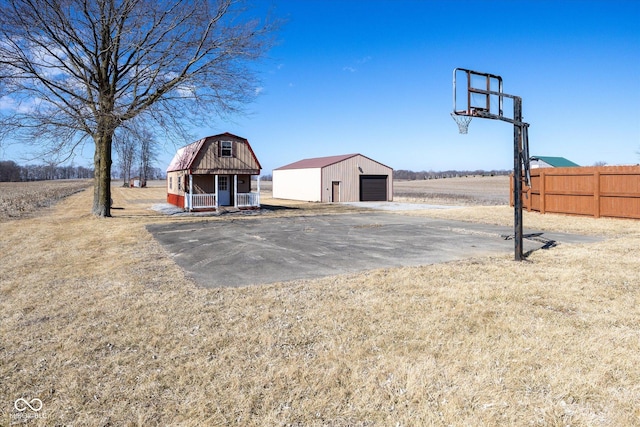 view of basketball court featuring a yard and fence