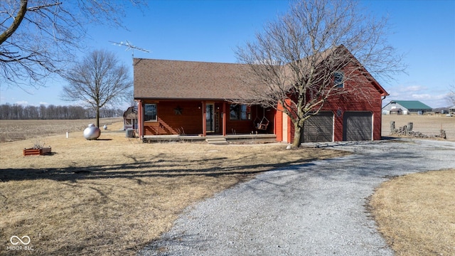 view of front of property featuring driveway, covered porch, and a garage