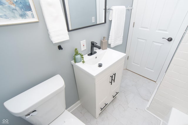 bathroom featuring toilet, marble finish floor, vanity, and baseboards