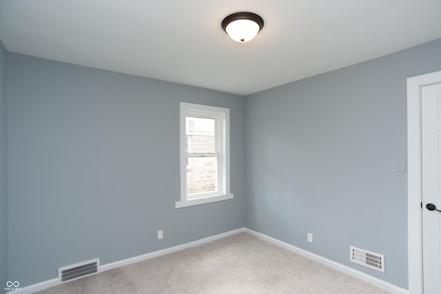 carpeted spare room with baseboards and visible vents