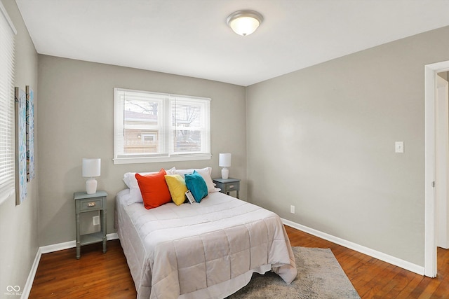 bedroom with baseboards and wood finished floors