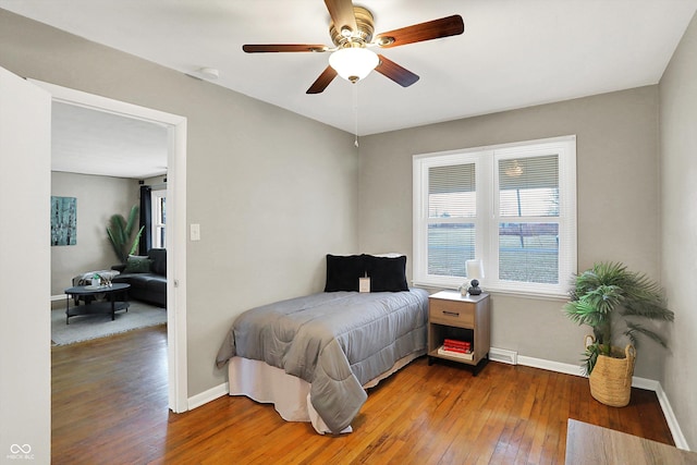 bedroom featuring wood-type flooring, baseboards, and a ceiling fan