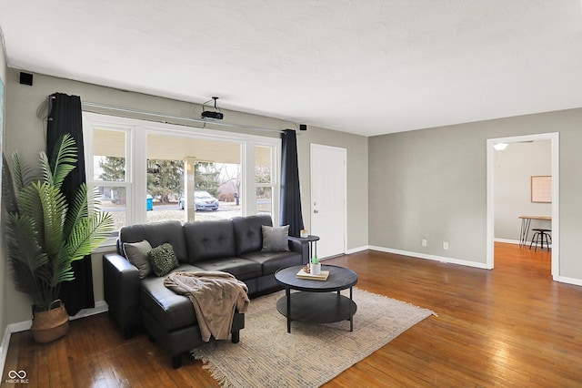 living area with wood-type flooring and baseboards