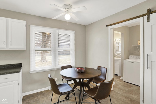 dining room with washer / dryer, a ceiling fan, a healthy amount of sunlight, and a barn door