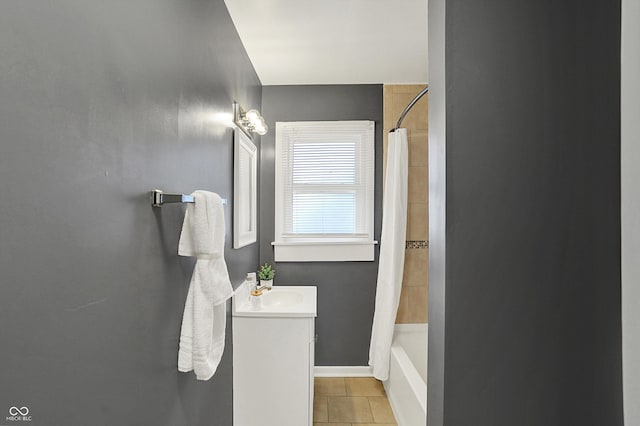 bathroom featuring shower / bath combo with shower curtain, tile patterned flooring, vanity, and baseboards