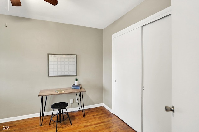 office area with ceiling fan, baseboards, and wood finished floors