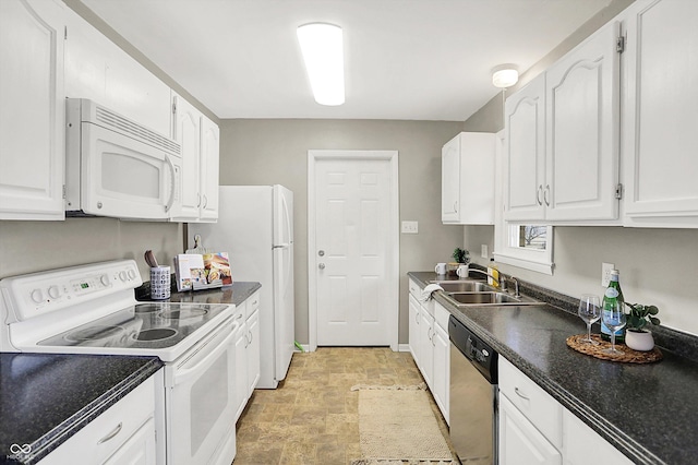 kitchen with white appliances, a sink, baseboards, white cabinets, and dark countertops