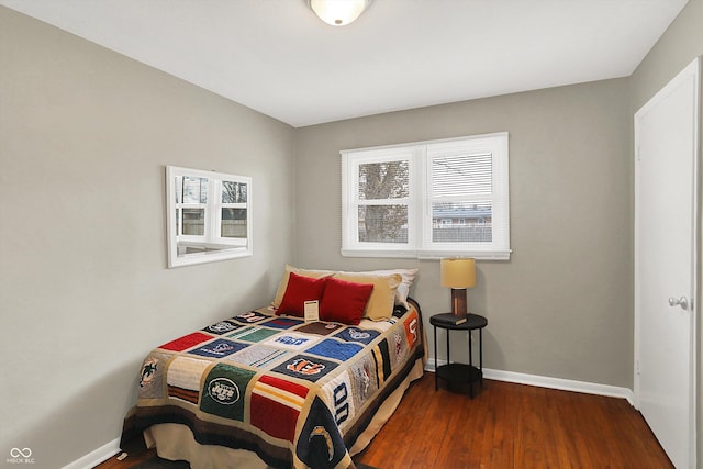 bedroom with baseboards and wood finished floors