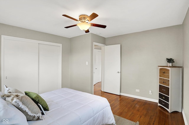 bedroom featuring a closet, wood-type flooring, baseboards, and a ceiling fan