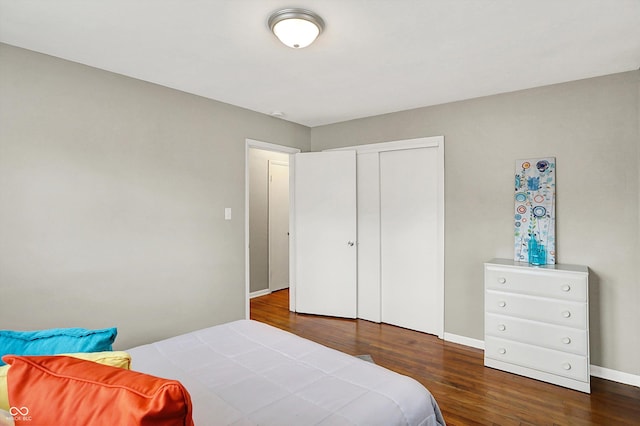 bedroom featuring a closet, wood finished floors, and baseboards