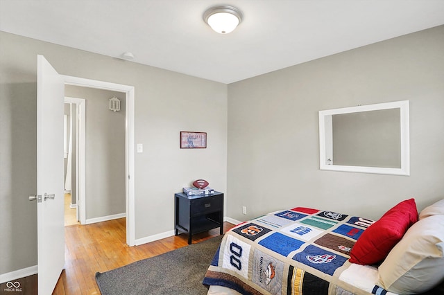 bedroom with baseboards and hardwood / wood-style flooring