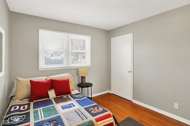 bedroom with baseboards and wood finished floors