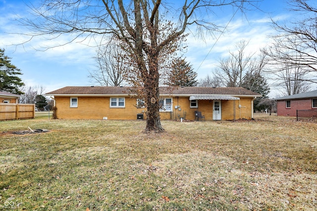 back of house featuring a lawn and fence