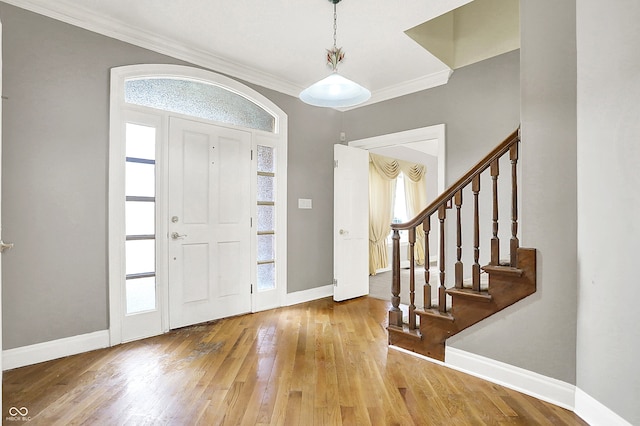 entryway with crown molding, stairway, hardwood / wood-style flooring, and baseboards