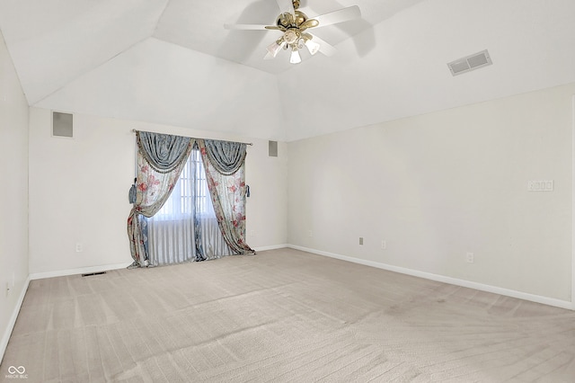 spare room featuring vaulted ceiling, carpet, and visible vents