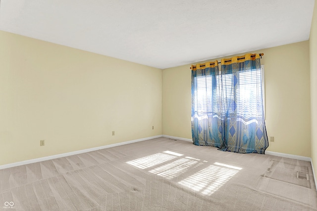 spare room featuring carpet, baseboards, and visible vents