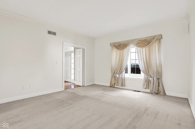 empty room featuring carpet floors, visible vents, crown molding, and baseboards