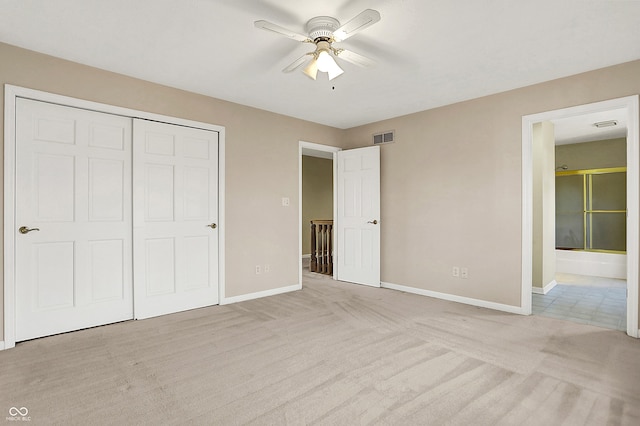 unfurnished bedroom with a closet, light colored carpet, visible vents, a ceiling fan, and baseboards