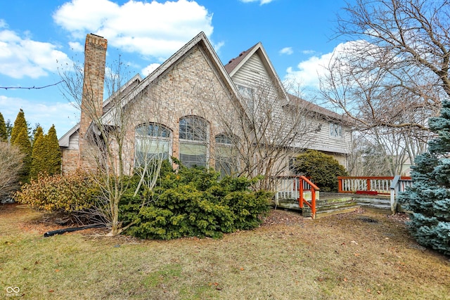 exterior space featuring a front yard, a chimney, and a wooden deck