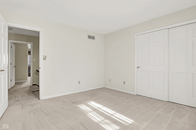 unfurnished bedroom with baseboards, visible vents, and a closet