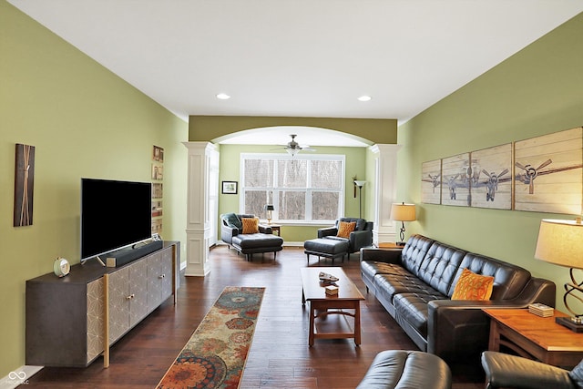 living area with decorative columns, arched walkways, a ceiling fan, dark wood-type flooring, and recessed lighting