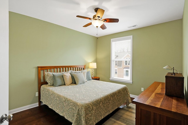 bedroom featuring visible vents, dark wood finished floors, baseboards, and ceiling fan