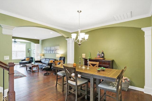 dining room with ceiling fan with notable chandelier, ornate columns, and wood finished floors