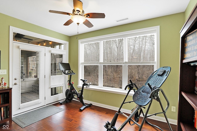 workout area featuring baseboards, visible vents, ceiling fan, and wood finished floors