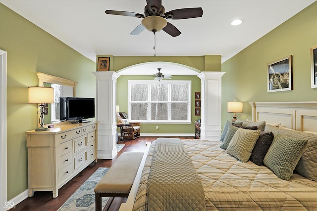 bedroom with arched walkways, dark wood-style flooring, baseboards, and ornate columns