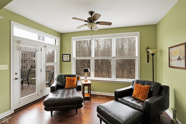 sitting room with dark wood-type flooring, visible vents, ceiling fan, and baseboards