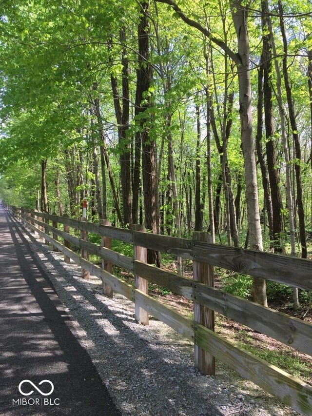 view of community with fence and a view of trees