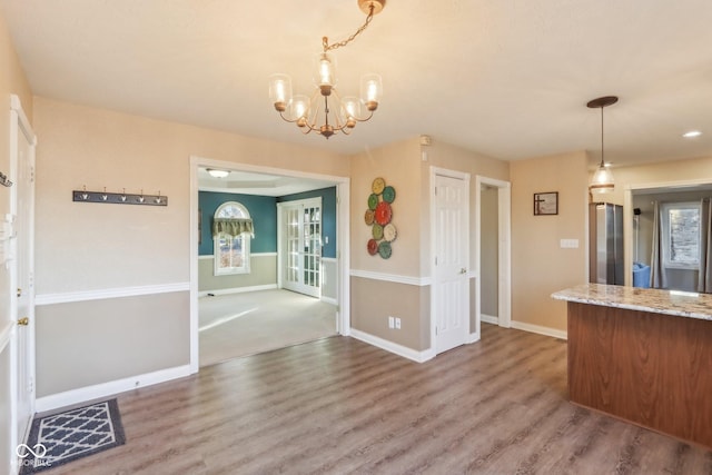 kitchen with freestanding refrigerator, pendant lighting, baseboards, and wood finished floors