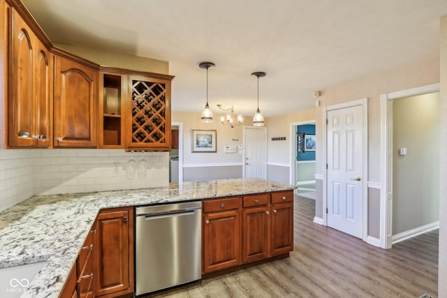 kitchen with light wood-style flooring, a peninsula, backsplash, dishwasher, and pendant lighting