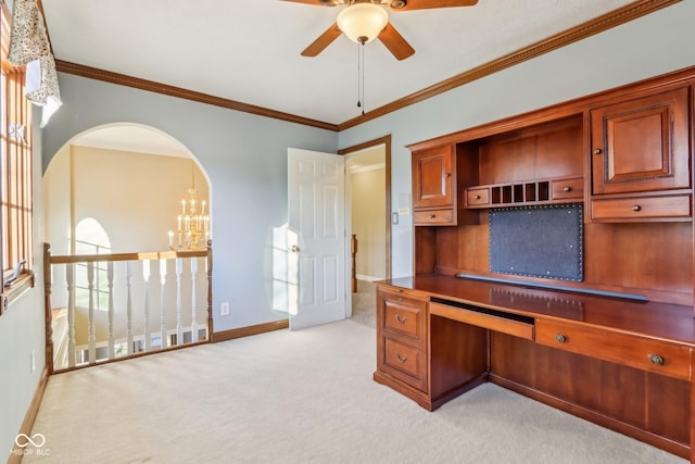 unfurnished office featuring ornamental molding, arched walkways, light colored carpet, and baseboards