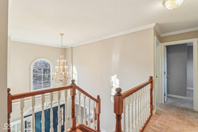 hallway featuring a chandelier, carpet flooring, crown molding, and an upstairs landing