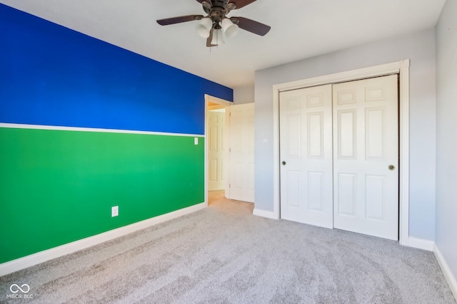 unfurnished bedroom with carpet floors, a ceiling fan, baseboards, and a closet