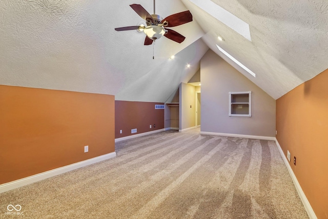 bonus room featuring a textured ceiling, carpet flooring, visible vents, and baseboards