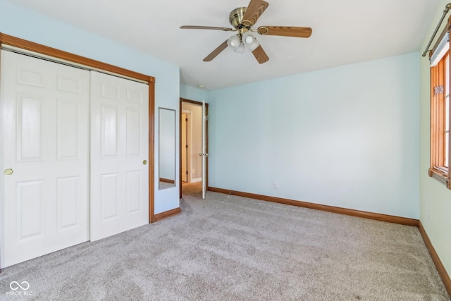 unfurnished bedroom featuring carpet floors, a closet, ceiling fan, and baseboards