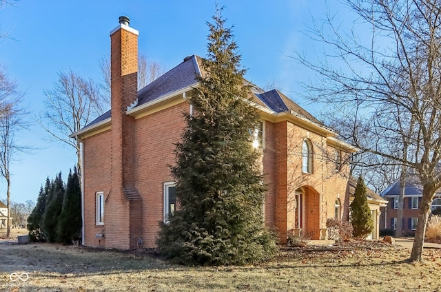 view of home's exterior featuring a chimney and brick siding