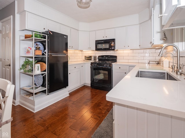 kitchen with black appliances, white cabinetry, light countertops, and a sink