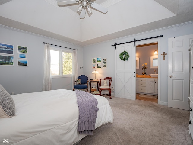 bedroom featuring a raised ceiling, light carpet, crown molding, and a barn door