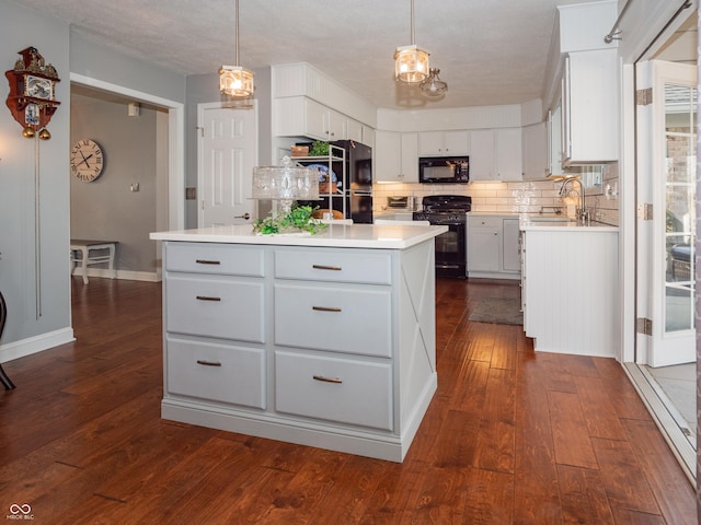 kitchen featuring black appliances, tasteful backsplash, light countertops, and a sink