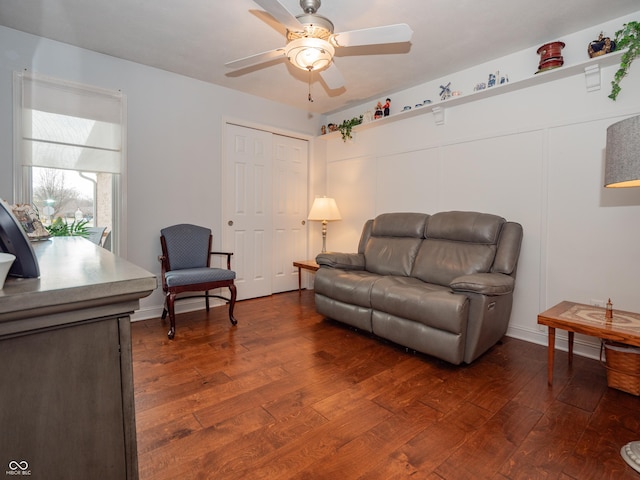 living room featuring dark wood finished floors and a ceiling fan