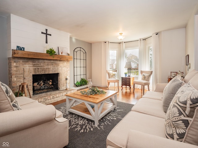 living area with a brick fireplace and wood finished floors