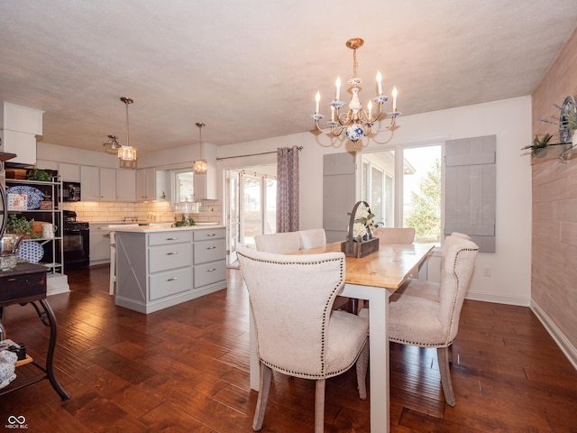 dining room featuring a chandelier, dark wood finished floors, and baseboards